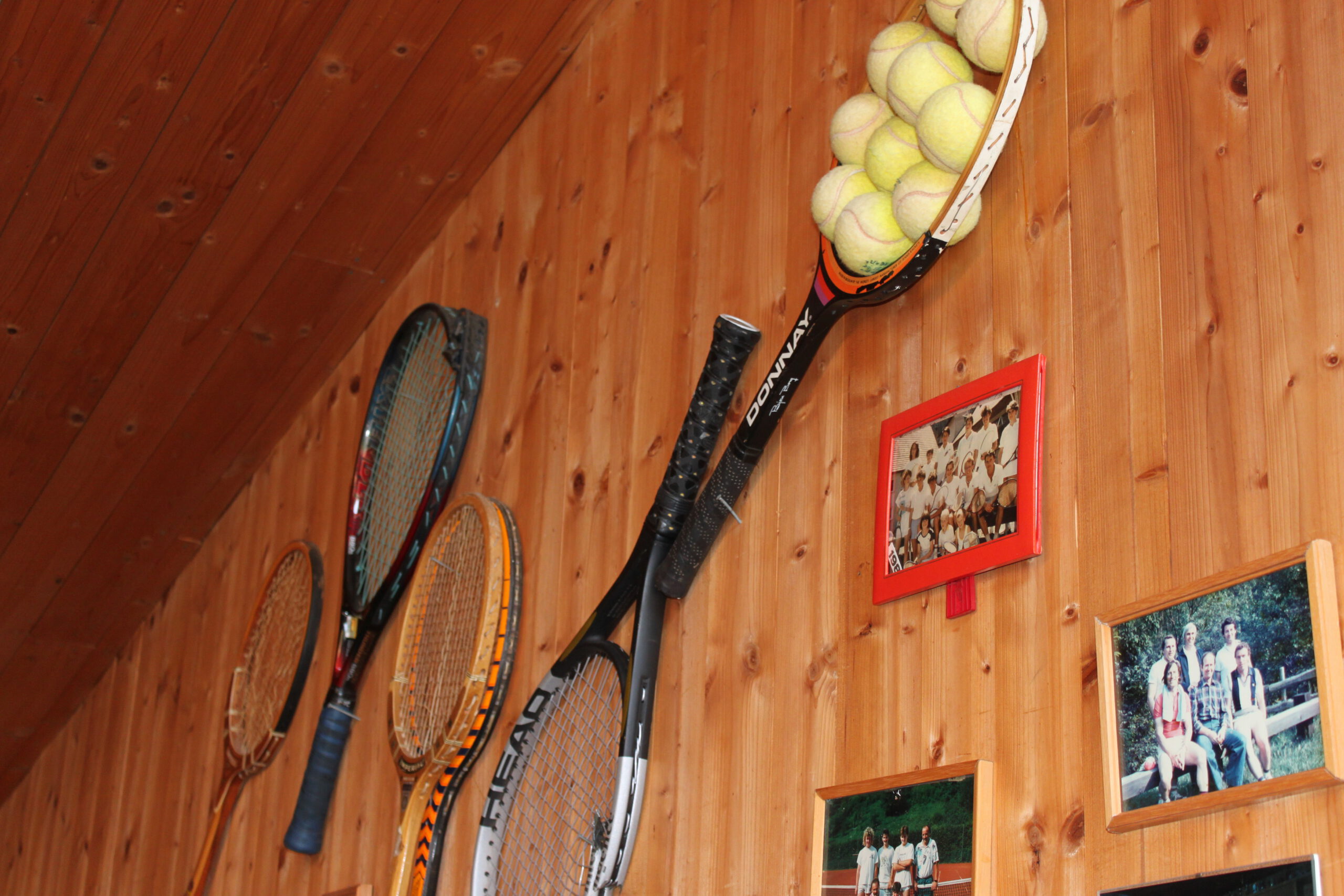 Wand mit Tennisschläger und Bilder